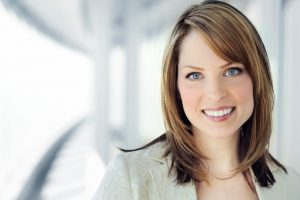 Image of a smiling woman with professional hairstyle.